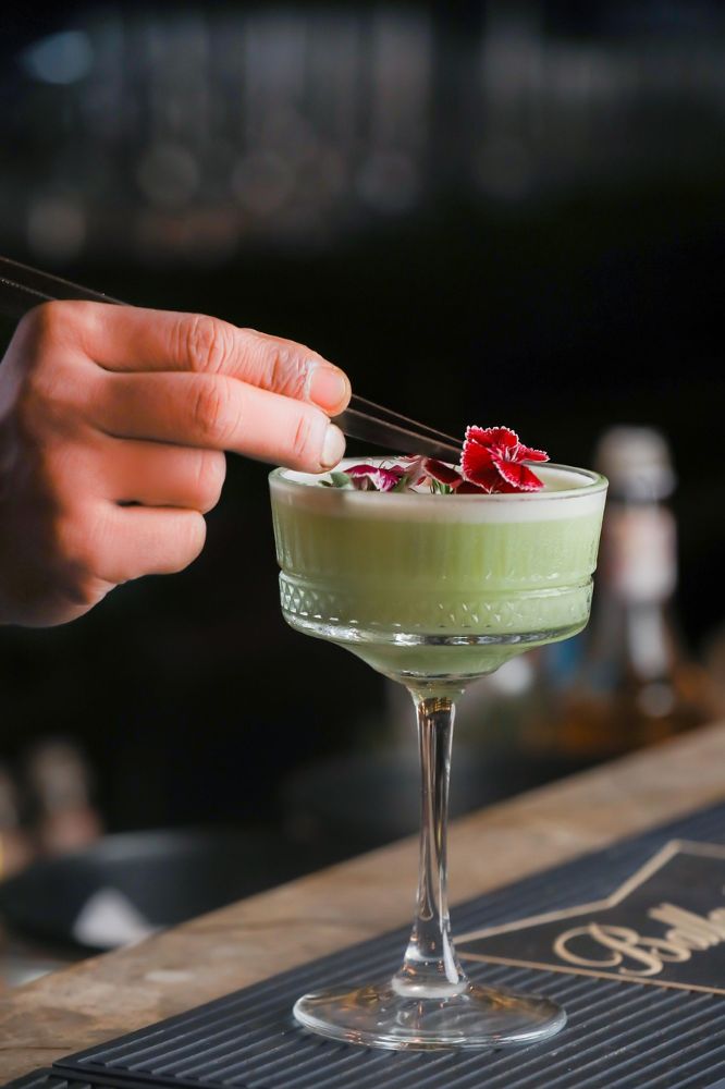 A bartender garnishing a cocktail