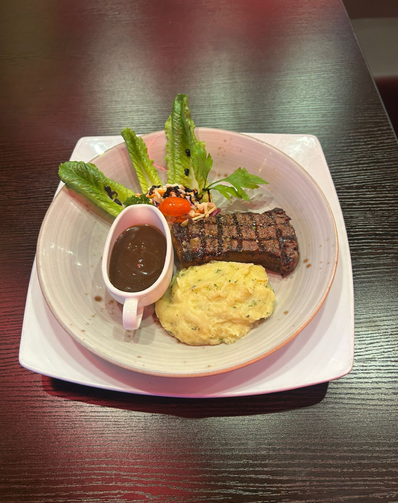 Grilled steak with mash and greens